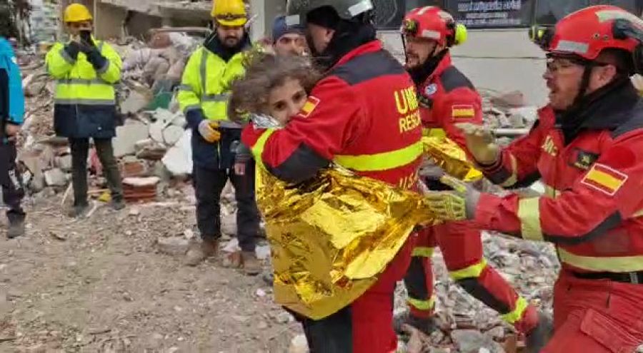 Un efectivo de la UME lleva en brazos a la niña rescatada en Nurdagi junto a su hermano y su madre
