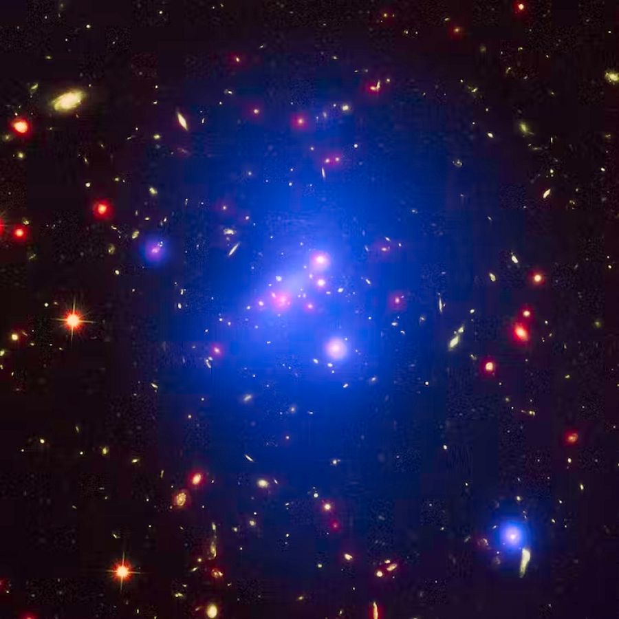 Imagen del cúmulo galáctico IDCS 1426 formada por una composición de datos de tres instrumentos: rayos X del telescopio espacial Chandra (en azul), luz visible del Hubble (en verde) e infrarrojos del Spitzer (en rojo). X-ray: NASA/CXC/Univ of Missou