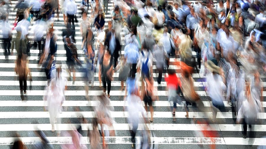 Multitud de personas atravesando un paso de peatones de la calle