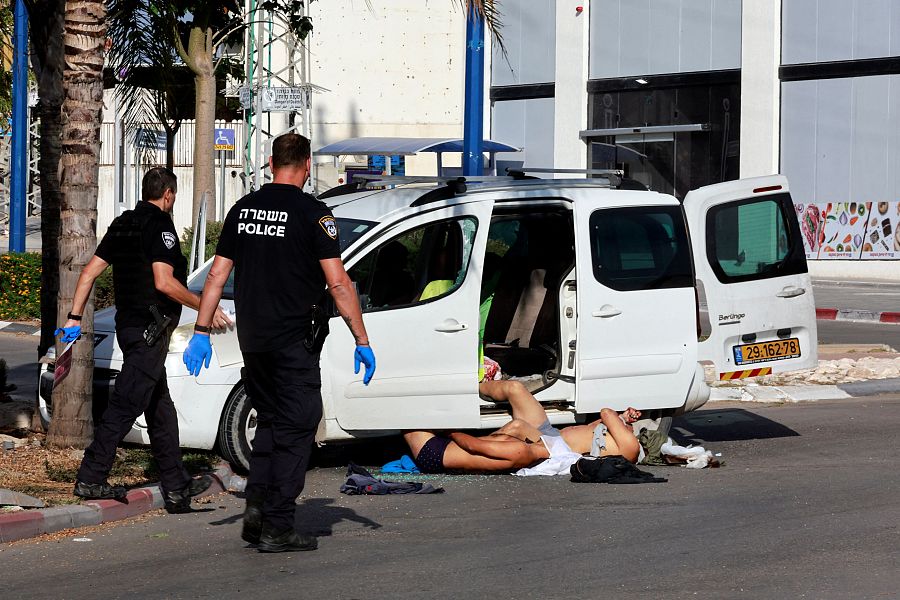La policía israelí junto a los cadáveres de dos personas tiroteadas por las milicias de Hamás en Sderot