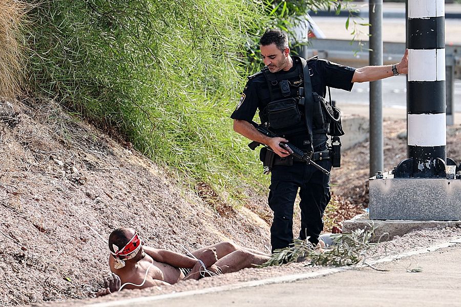 Un policía israelí junto a un prisionero palestino