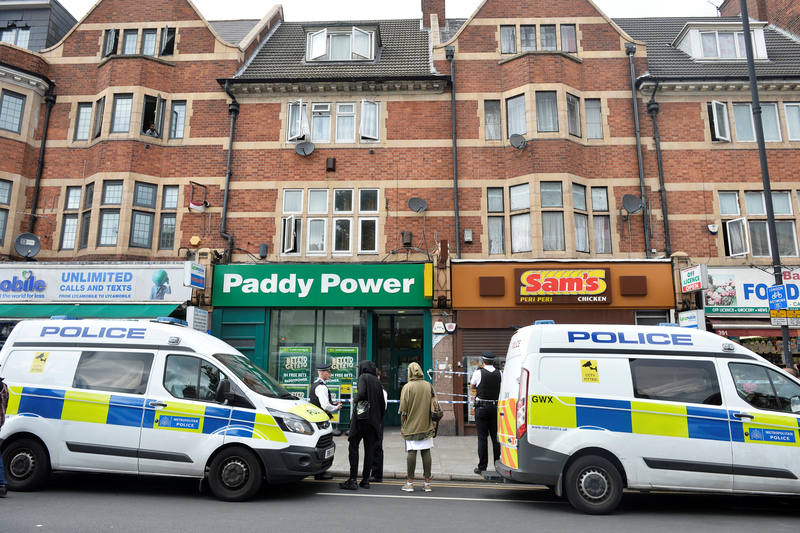 Agentes de policía permanecen frente a uno de los edificios donde se ha llevado a cabo un registro en Barking Road, Londres