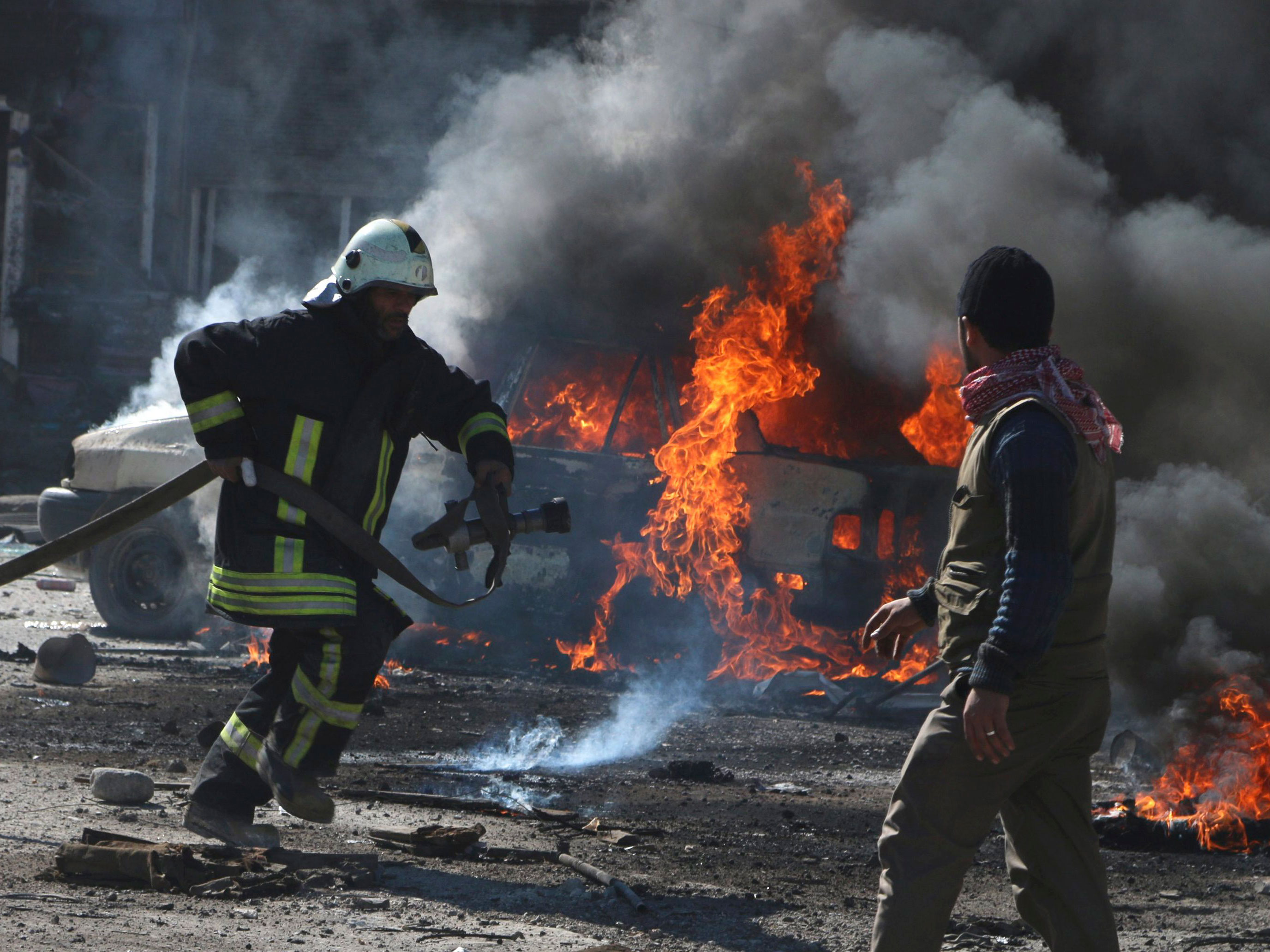 Un bombero trata de apagar el incendio provocado por un barril cargado de dinamita.