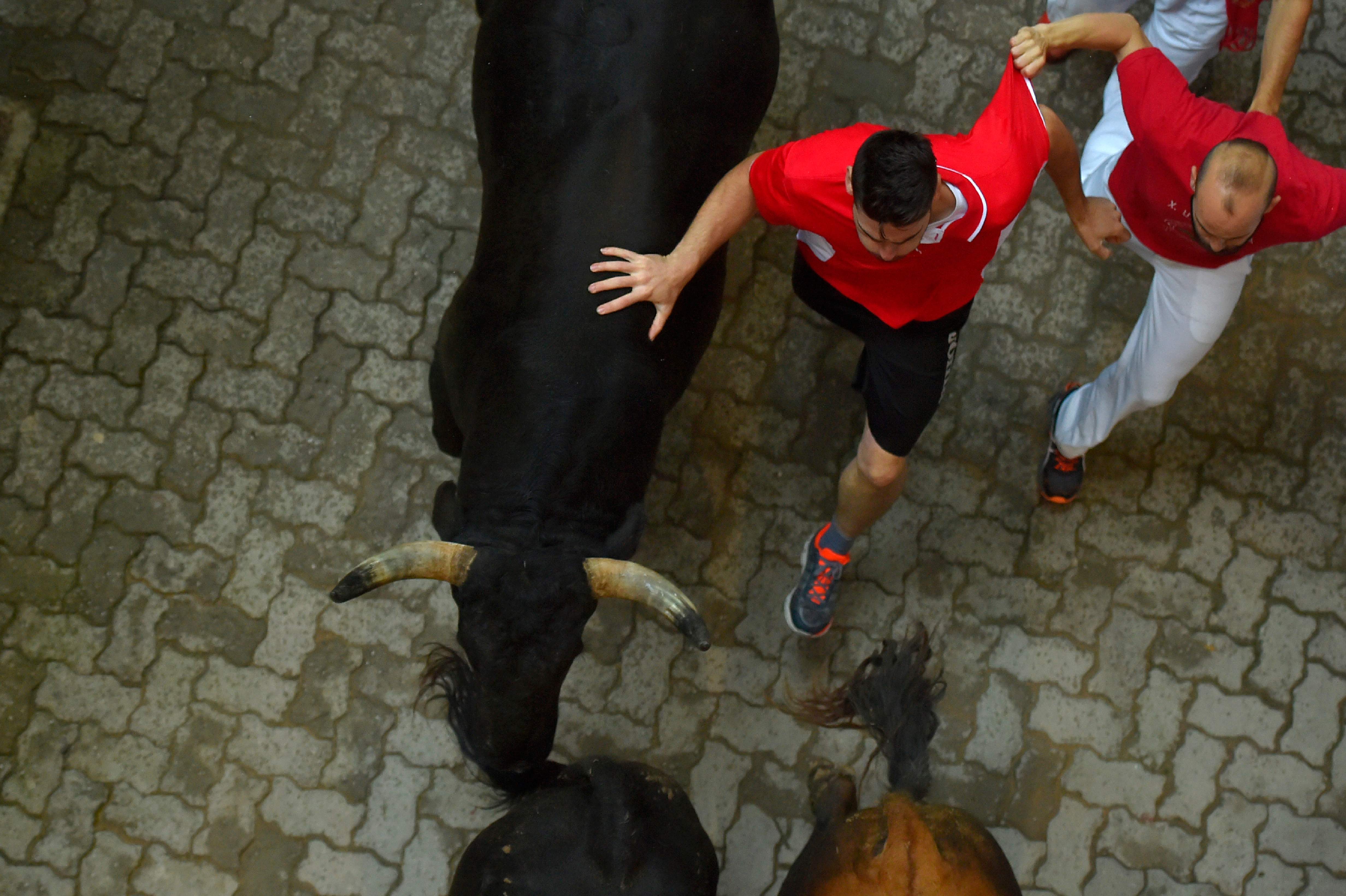 Un corredor acaricia el lomo de un toro de Victoriano del Río
