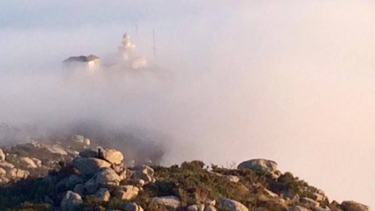 El Faro de Finisterre asoma entre la densa capa de nubes y anuncia el final del camino El Faro de Finisterre asoma entre la densa capa de nubes y anuncia el final del camino