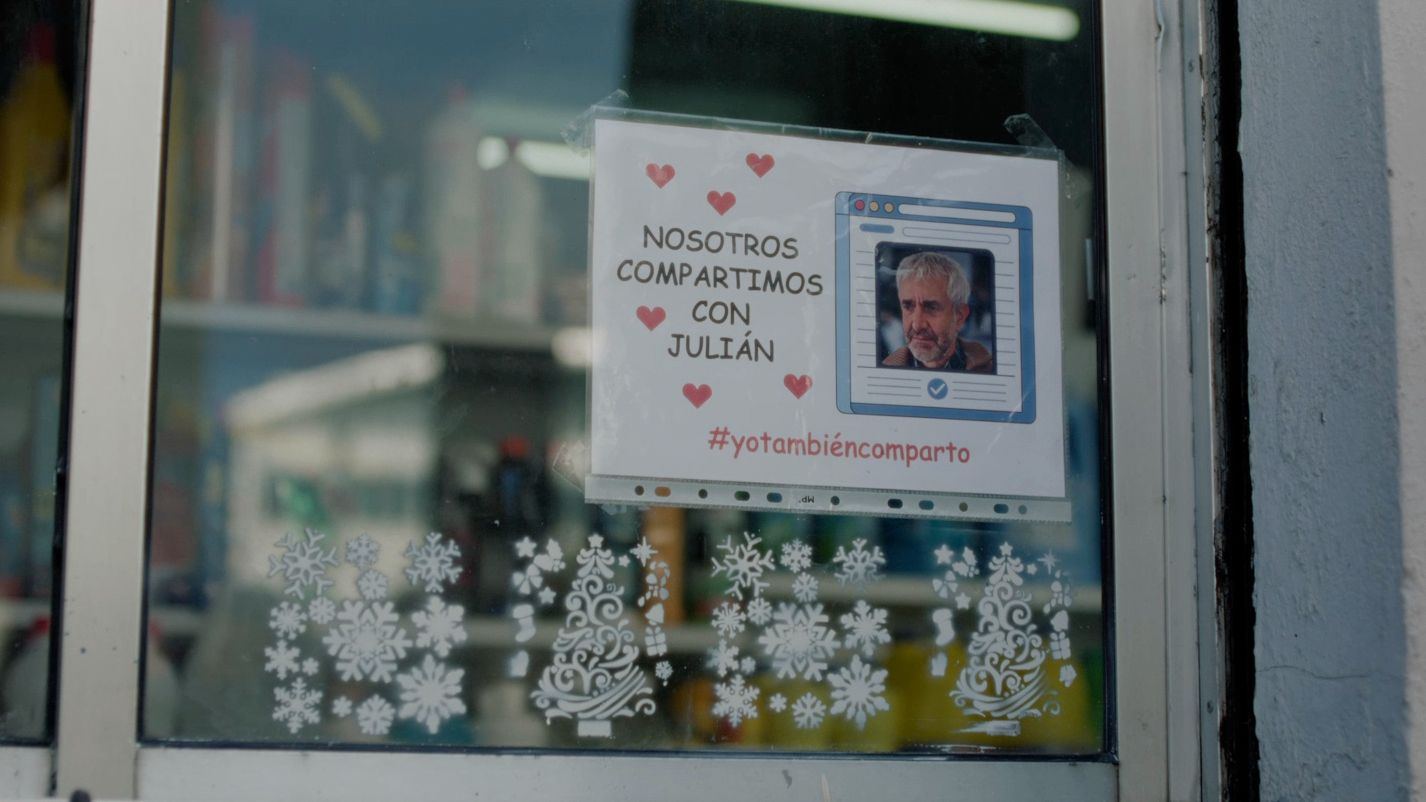 En un escaparate, un cartel con la foto de Julián y el mensaje