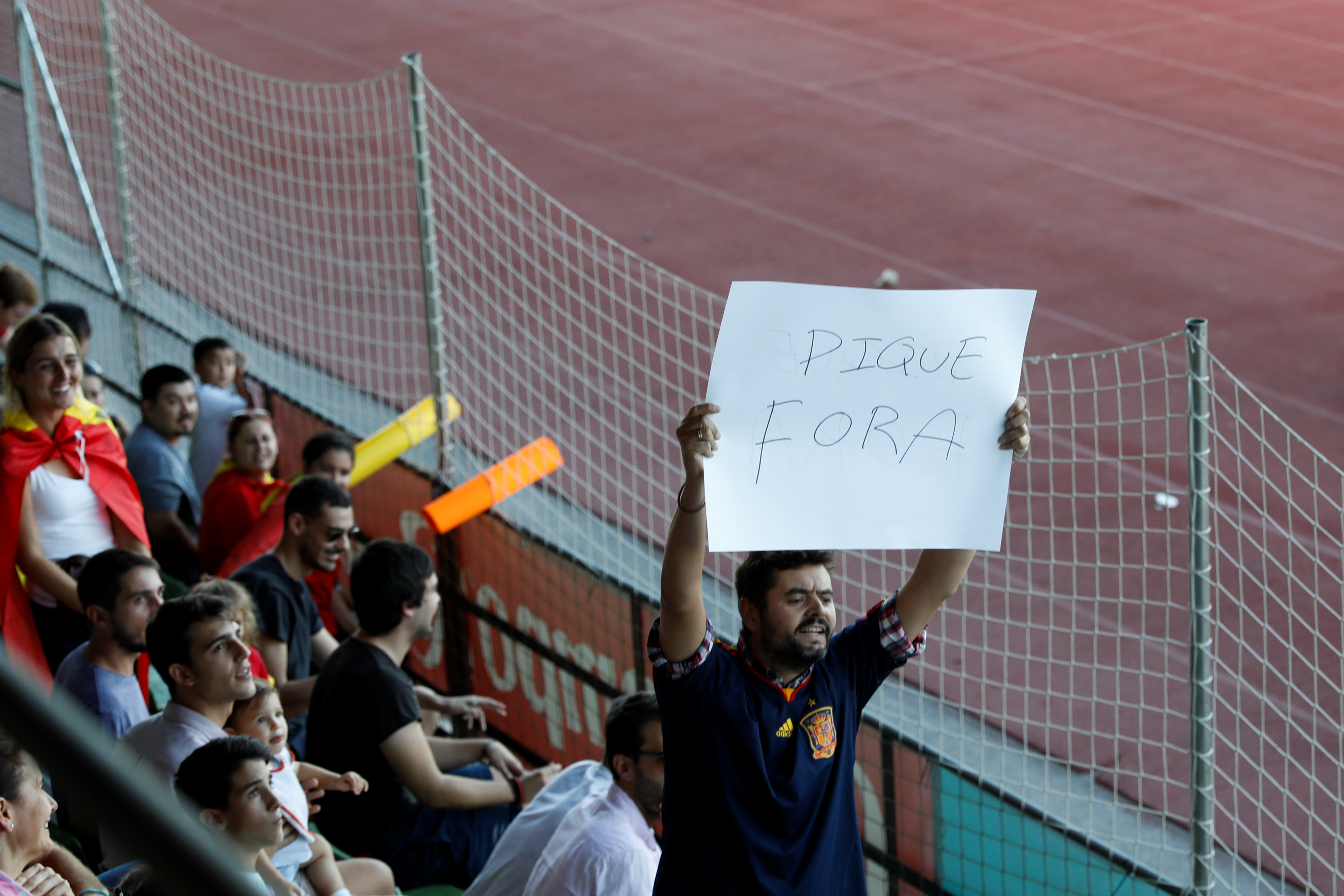 Un hombre con una pancarta en la que se puede leer "Fuera Piqué".