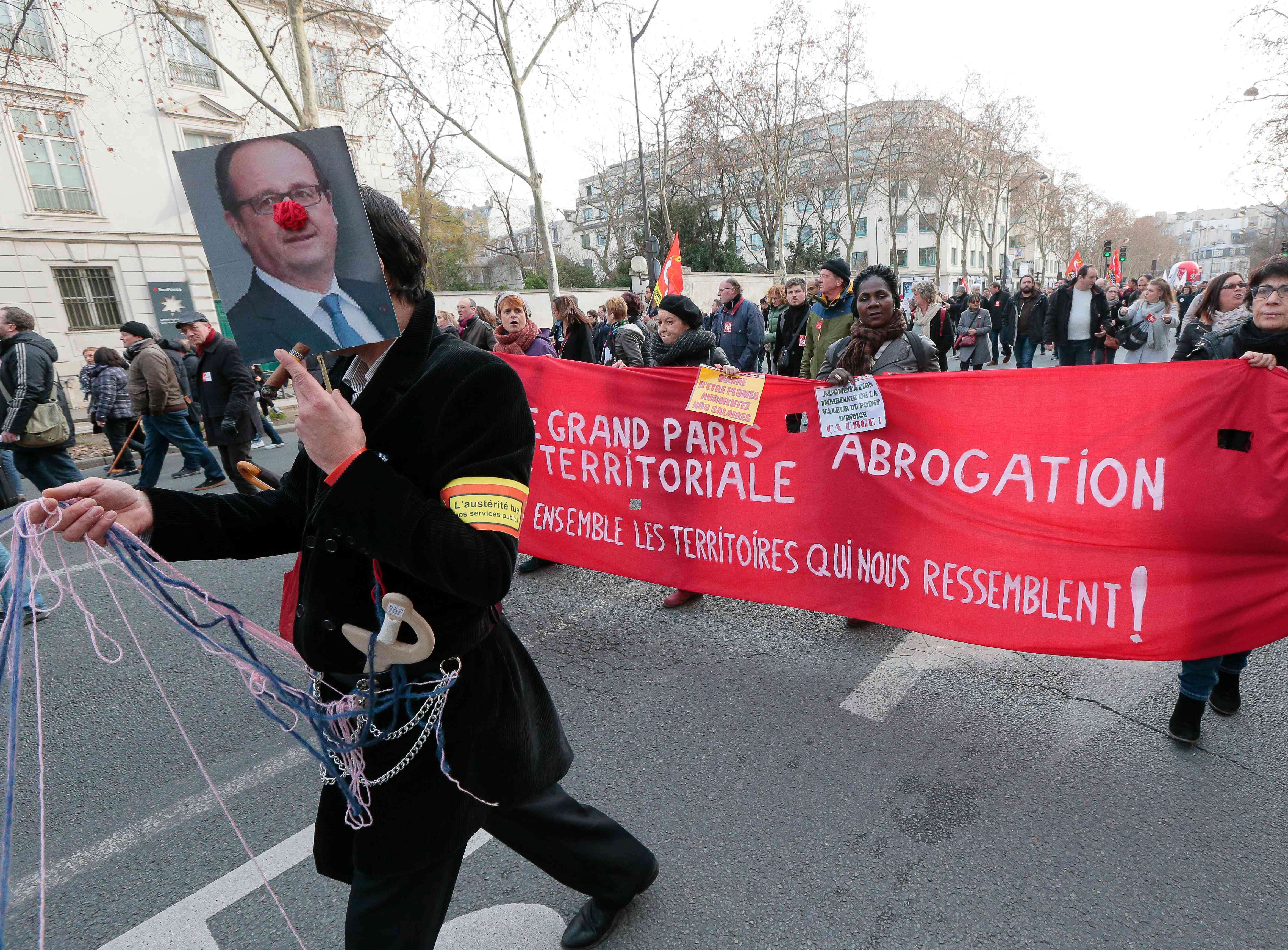 Un manifestante sostiene un retrato de Hollande con una nariz de payaso Un manifestante sostiene un retrato de Hollande con una nariz de payaso