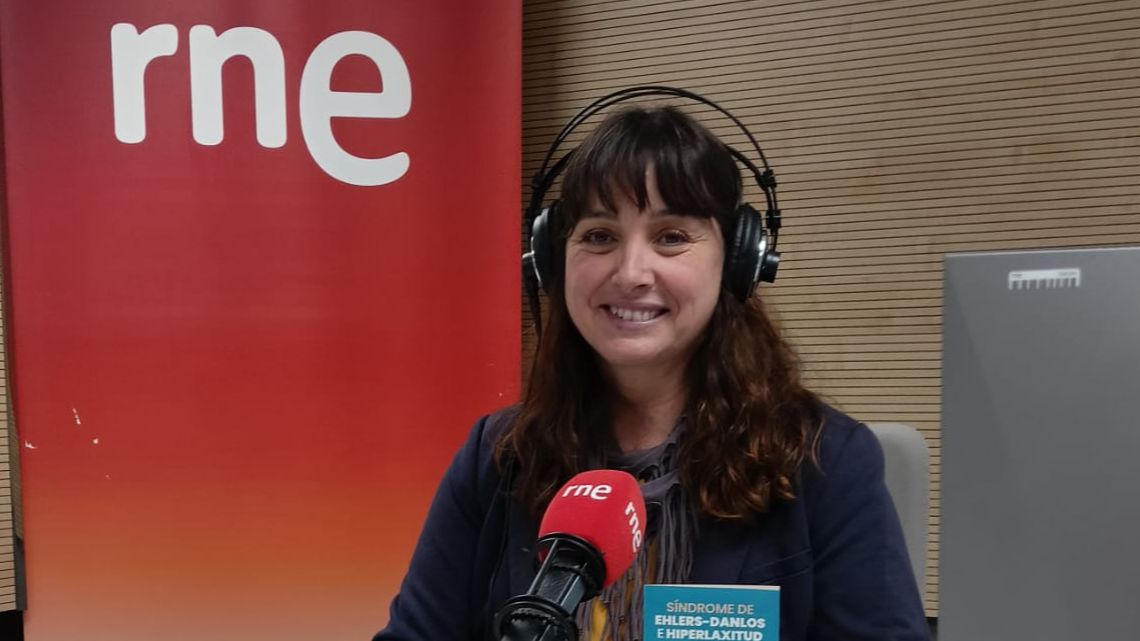 Presentadora de RNE en estudio de radio, con auriculares, hablando a micrófono sobre