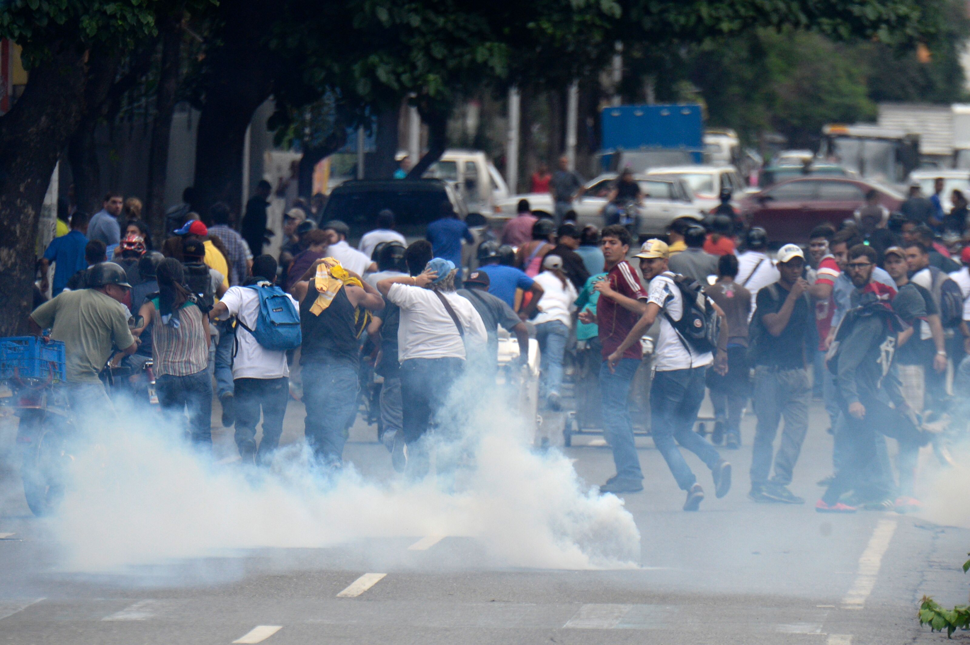 La Policía disuelve la protesta en contra de Maduro Gente corre por una calle de Caracas después de que la Policía disparara gases lacrimógenos para disolver una manifestación convocada en contra de Nicolás Maduro
