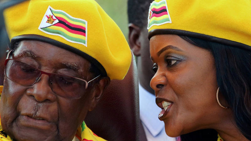 El presidente de Zimbabue, Robert Mugabe, escucha a su mujer, Grace, en un mitin del partido ZANU-PF