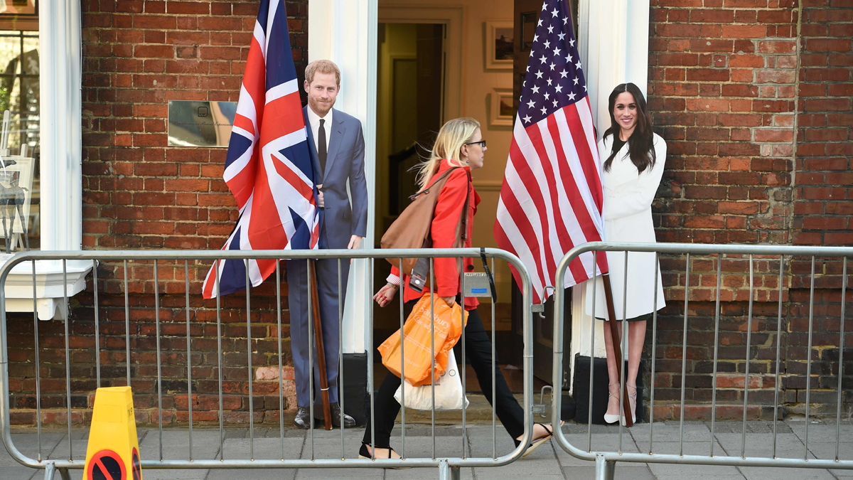 Una vecina de Windsor pasa por delante de las figuras de cartón de Enrique y Meghan