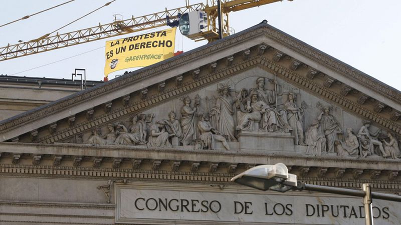 Activistas de Greenpeace protestan durante cuatro horas en una grúa del Congreso contra la 'ley mordaza'