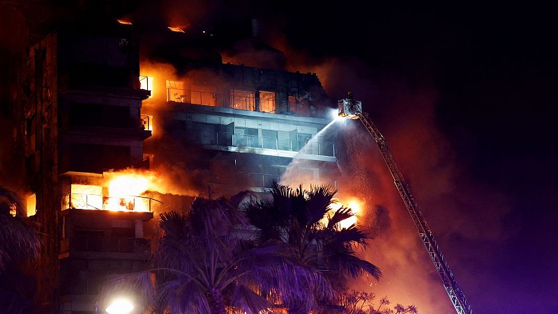 Los bomberos rescatan a dos personas atrapadas en el edificio incendiado en Valencia