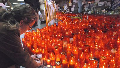 Una joven deja una vela en recuerdo de las vctimas del atentado del 11-M