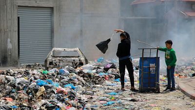 Dos nios buscan entre la basura en una calle de Gaza