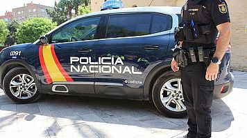 Imagen de archivo de un agente y vehculo de la Polica Nacional (AGENCIAS)