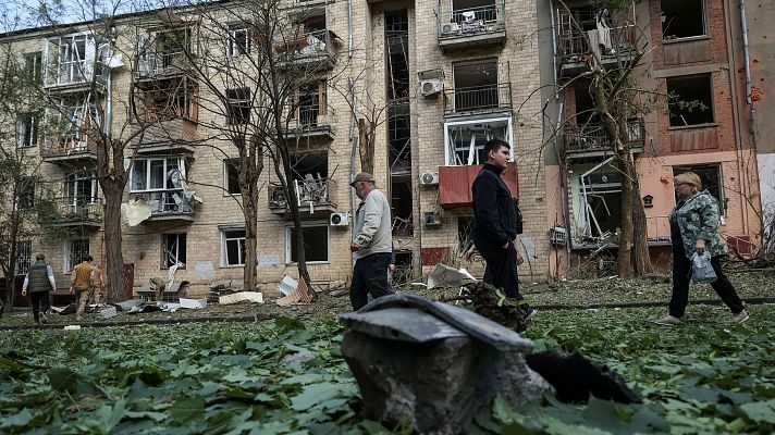 Varias personas pasan junto a un edificio daado por las bombas en Jrkov