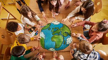 Varios alumnos de primaria dibujan el planeta Tierra en la clase de arte