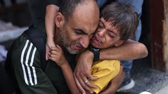 Un nio palestino recibe consuelo mientras est cerca de una bolsa para cadveres (invisible) tras el bombardeo israel de un barrio de la ciudad de Gaza, en el hospital rabe Al-Ahli