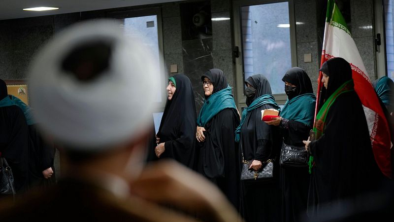 Los ciudadanos iranes esperan en cola para emitir sus votos durante la segunda vuelta de las elecciones presidenciales