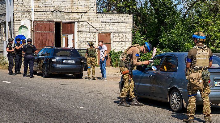 Polica y militares ucranianos de la Guardia Nacional controlan la carga de vehculos en un puesto de control en las afueras de Jrkov