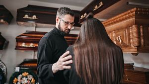 Un treballador d'una funerria consola una clienta.