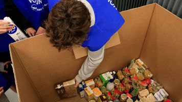 Un voluntari colloca els aliments recollits