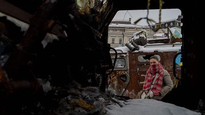 Una mujer mira vehculos militares rusos destruidos frente al Monasterio de las Cpulas Doradas de San Miguel en el centro de Kiev