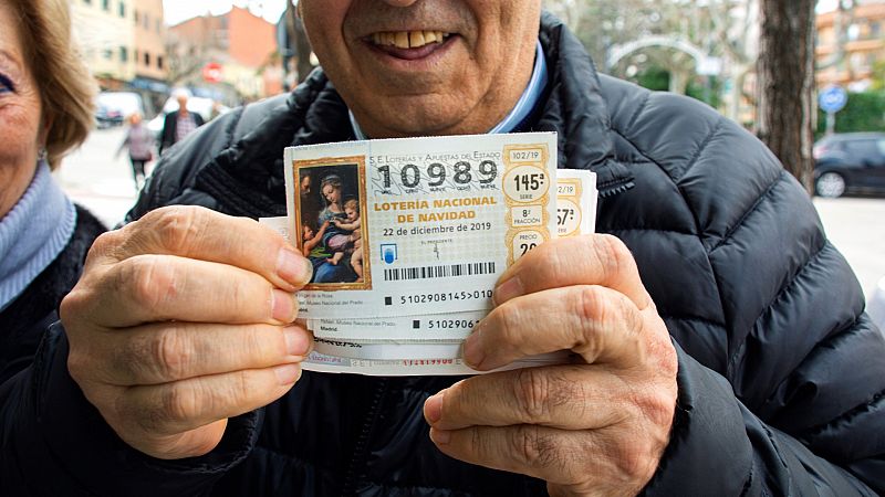 Un hombre sostiene un d�cimo premiado del Sorteo Extraordinario de Navidad de 2019