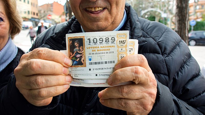 Un hombre sostiene un dcimo premiado del Sorteo Extraordinario de Navidad de 2019