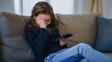 Ni�a llora con m�vil en la mano