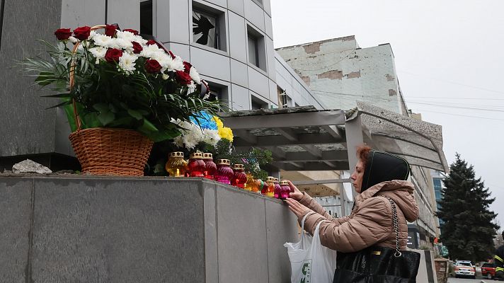 Una mujer ucraniana llevan flores cerca del lugar donde se produjo el impacto de un cohete contra una clnica privada en Zaporizhzhia, sureste de Ucrania, el 11 de diciembre de 2024