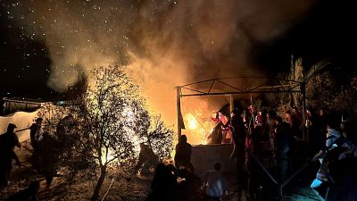 La poblacin desplazada en la zona humanitaria observa el fuego en las tiendas de campaa