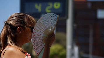 Una mujer se abanica junto a un termmetro de calle que marca 42 grados en Crdoba