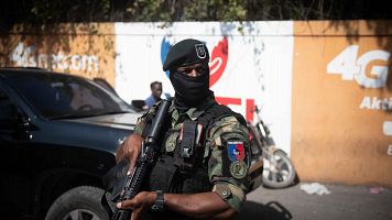 Un polica vigila una jornada de reparticin de alimentos n Puerto Prncipe, Hait