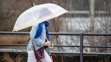 Una mujer se protege de la lluvia en Logroo