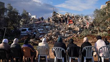 Mujeres palestinas miran los escombros de una casa donde dos militantes palestinos fueron asesinados por Israel en Burqin, cerca de Yenn, Cisjordania