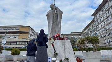 Fieles improvisan un altar por el papa con flores y velas a las puertas del hospital