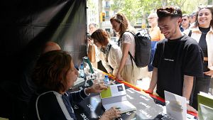 Slvia Soler i Xavier Bosch amb cues de persones esperant per poder signar els seus exemplars | ACN