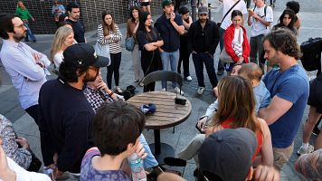 Un grupo de gente escucha la radio en una calle de Madrid durante el apagón del 28 de abril (Thomas COEX/AFP)