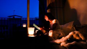 Una mujer lee en su casa con ayuda de una vela en la localidad de El Masnou (Barcelona) durante el apagn del 28 de abril