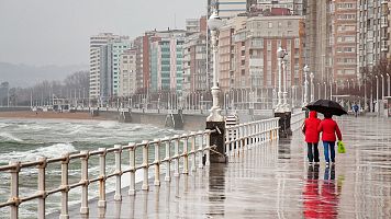 El tiempo hoy 22 de mayo: dos personas pasean bajo la lluvia en Gijón