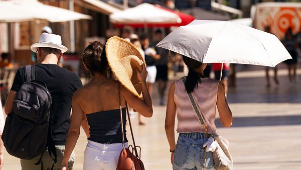 Varias personas se refugian del sol en Málaga