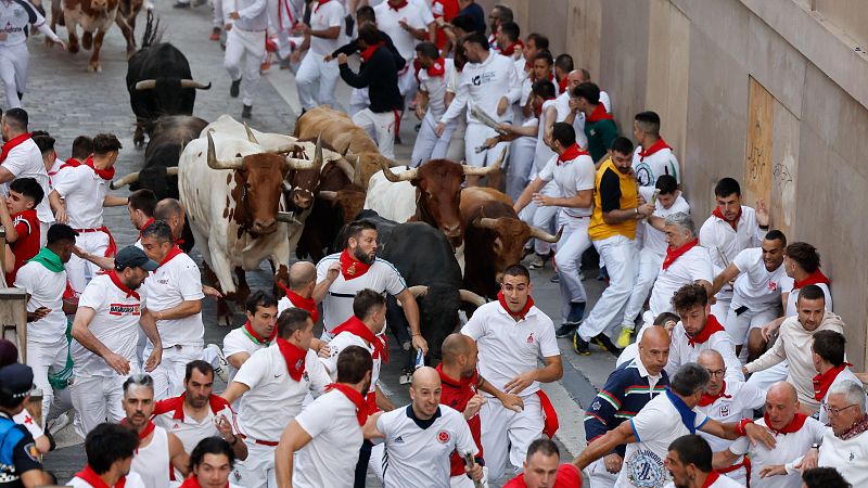 Quinto encierro de San Fermn 2025, al detalle: dos mozos se agarran y corren juntos delantedeltoro