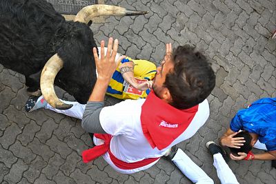San Fermn 2025: uno de los toros pasa a milmetros de uno de los corredores del sptimo encierro