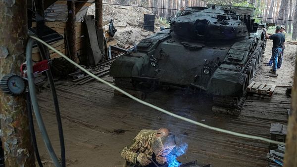Un soldado de la 57 Brigada de Infantera Motorizada Separada de las Fuerzas Armadas de Ucrania repara un tanque