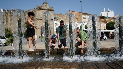 Una familia se refresca en una fuente en Plasencia