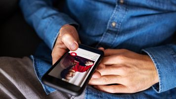 Primer plano de un hombre usando Tinder en su telfono mvil