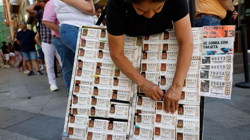 Una mujer vende décimos de lotería de Navidad en Madrid
